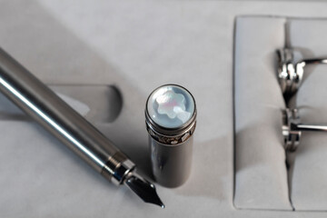 Fountain pen with box on dark gray background. Stationery branded items