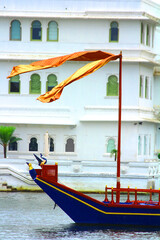 waving flag in the air at a boat in lake pichola