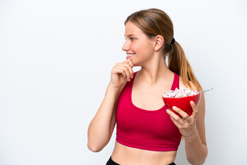 Young pretty blonde woman having breakfast milk isolated on white background thinking an idea and...