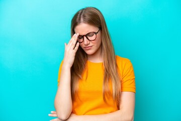 Young caucasian woman isolated on blue background with headache