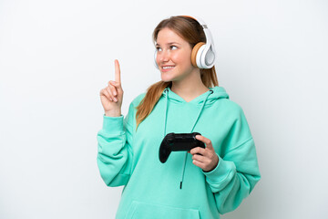 Young caucasian woman playing with a video game controller isolated on white background pointing up...