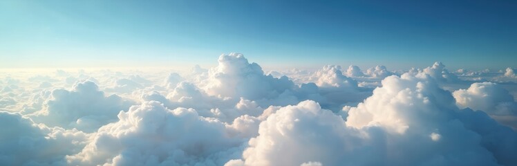 Fluffy white clouds blanket sky above sea of clouds. Sunlight breaks through, illuminating cumulus formations. Clear blue sky above creates serene, airy atmosphere. Perfect for travel, weather,