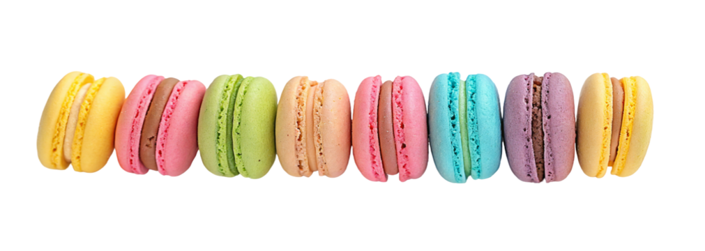 Assorted colorful macarons lined up on a white surface creating a visually appealing arrangement