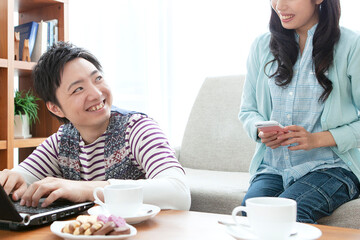 リビングでパソコンを見る夫婦