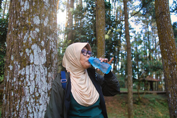 Woman Hydrating in Forest While Exploring Nature in Outdoor Environment