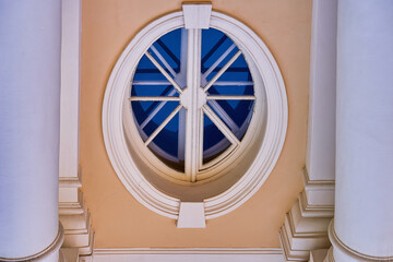 Old oval window on a yellow background