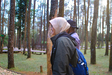 Individuals Exploring a Scenic Forest in Outdoor Attire on a Clear Day