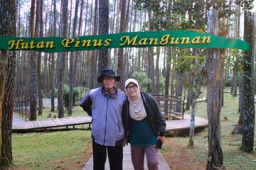 Senior Couple Posing in Scenic Pine Forest Wearing Casual Attire