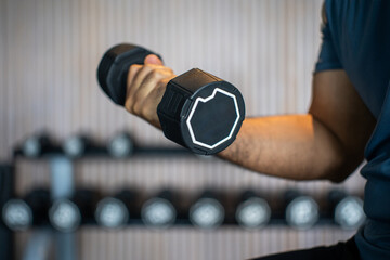 Young asian man weight training wearing sportswear. Asian exercise indoor gym lifting dumbbell....