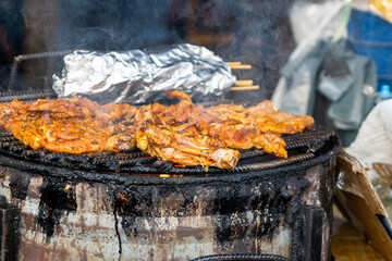 Sizzling chicken grilling over hot coals at streetside barbecue in Tortuguero, Costa Rica's vibrant coastal village