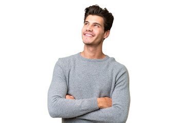 Young handsome caucasian man over isolated background looking up while smiling