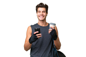 Young sport caucasian man with sport bag over over isolated background holding coffee to take away and a mobile