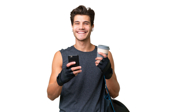 Young sport caucasian man with sport bag over over isolated background holding coffee to take away and a mobile - Powered by Adobe