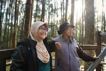 Smiling Senior Couple Enjoying a Scenic Forest Walk on a Bright Day