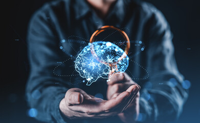 Futuristic concept of human intelligence and digital brain network held in hands with glowing...