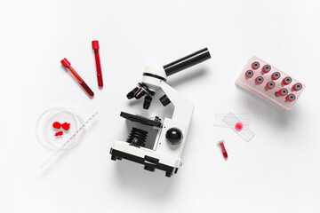 Modern microscope with blood samples and petri dish on white background