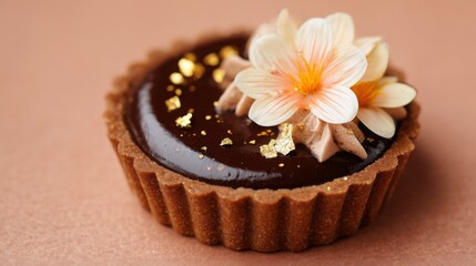 Delicate chocolate tart topped with edible flowers and gold accents handcrafted for a special occasion
