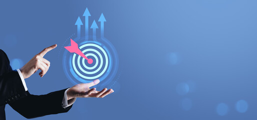 Businessman pointing at digital target with arrow and growth arrows, symbolizing achieving goals...