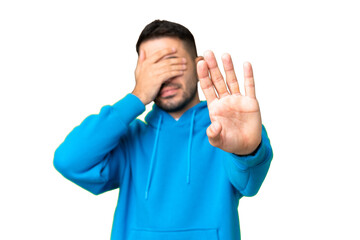 Young handsome caucasian man over isolated chroma key background making stop gesture and covering...