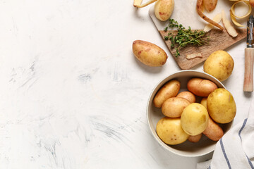 Bowl with raw baby potatoes and thyme on white background
