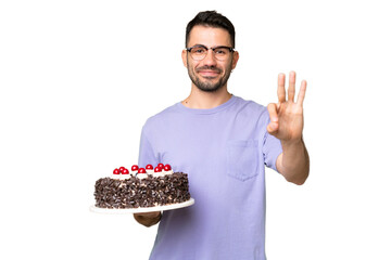 Young caucasian man holding birthday cake isolated on green chrome background happy and counting...