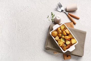 Baking dish of baked baby potatoes with thyme on white background