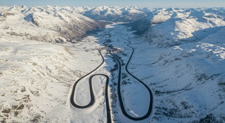 Aerial view of winding mountain road through snowy landscape