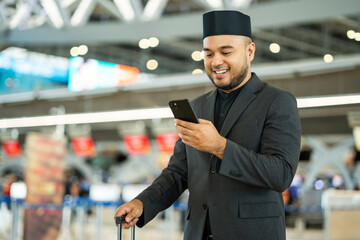 Muslim asian businessman traveler holding boarding pass ticket, passport and smartphone at the...
