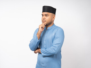 Portrait happy young asian muslim man thinking on isolated white background. Islamic Attractive Muslim man wearing songkok cap islam costume.