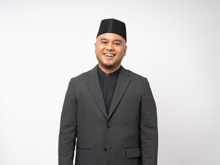 Portrait happy young asian muslim man in suit on isolated white background. Islamic Attractive Muslim man wearing songkok cap islam costume.