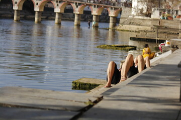 bridge over the river and people lying aside a ghat of udaipur