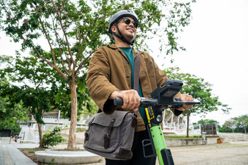 Young Asian man ride scooter EV eco friendly transport. Sustainable save energy lifestyle. Commute and carbon neutral transportation. Asian tourist man put on helmet ride the scooter EV