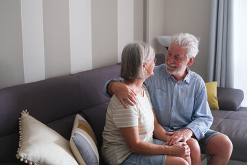 Senior couple in their 70s sharing loving and tender moments at home. A heartwarming scene of...