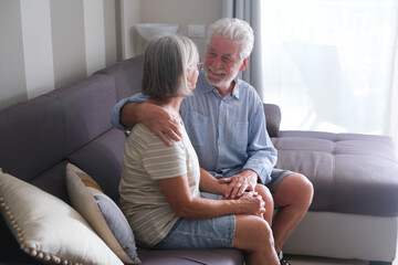 Senior couple in their 70s sharing loving and tender moments at home. A heartwarming scene of...