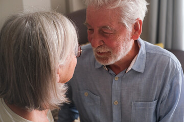 Senior couple in their 70s sharing loving and tender moments at home. A heartwarming scene of...