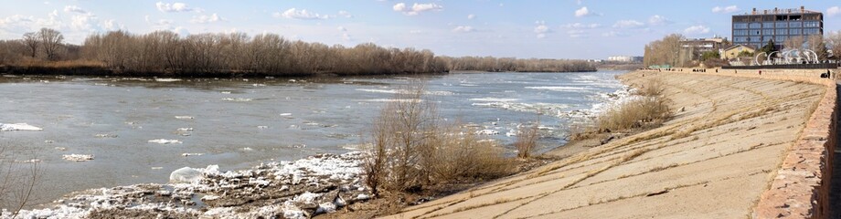 spring ice drift on the river on the city embankment with slabs
