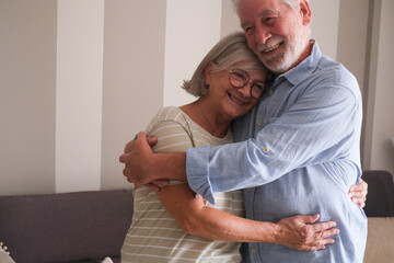 Senior couple in their 70s sharing loving and tender moments at home. A heartwarming scene of...