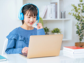 Girl studying on a laptop with headphones on