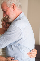 Senior couple in their 70s sharing loving and tender moments at home. A heartwarming scene of...