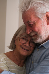 Senior couple in their 70s sharing loving and tender moments at home. A heartwarming scene of...
