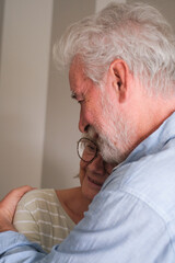 Senior couple in their 70s sharing loving and tender moments at home. A heartwarming scene of...