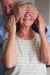 Senior couple in their 70s sharing loving and tender moments at home. A heartwarming scene of...