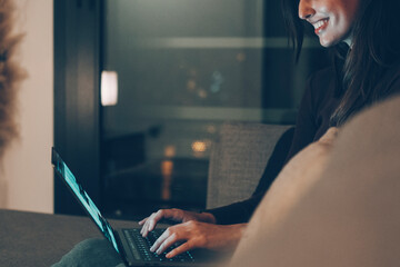 Young woman alone at home working late at night on her laptop. Freelancing, studying, chatting...