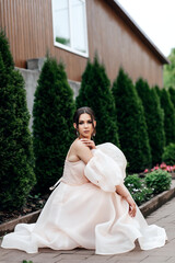 woman in light pastel dress sitting on path