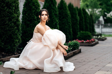 woman in light pastel dress sitting on path
