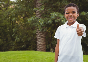 African American child giving thumbs-up on green lawn by palm tree in sunny park, copy space