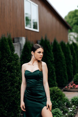 Girl in green emerald dress on the street in summer