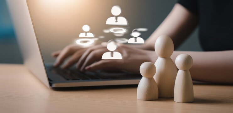 Modern digital networking concept with human icons on laptop screen and wooden figurines representing social connections and communication - Powered by Adobe