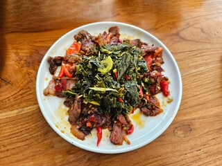 Delicious stir-fried vegetables with sliced meat served on a ceramic plate. Perfect for culinary blogs, restaurant menus, or healthy food promotions