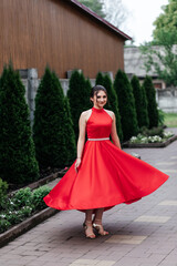 woman in red dress spinning on street in summer